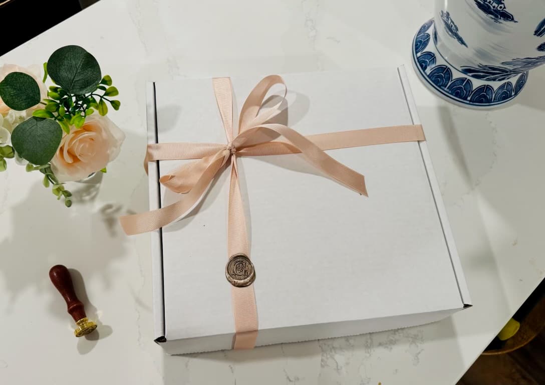 Gilded Tiers signature white gift box with blush ribbon and gold wax seal